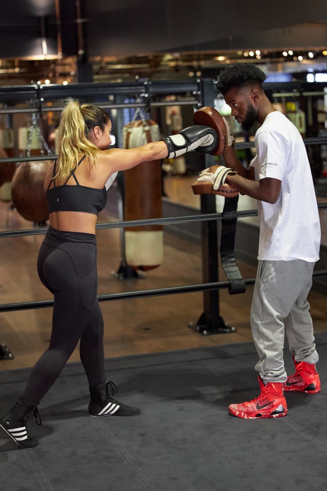 Coach holding mitts for a member in the ring